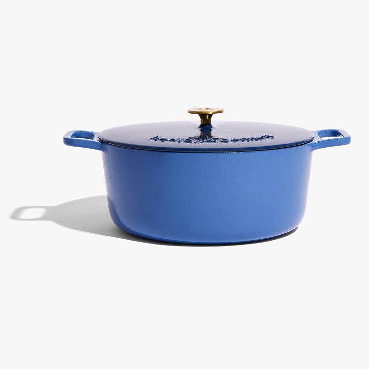 Blue enameled cast iron Dutch oven with a lid on a white background