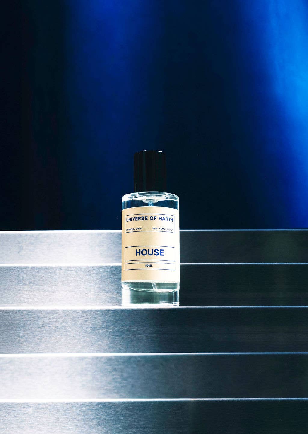 Small bottle labeled 'House' on a reflective surface with a dark blue background