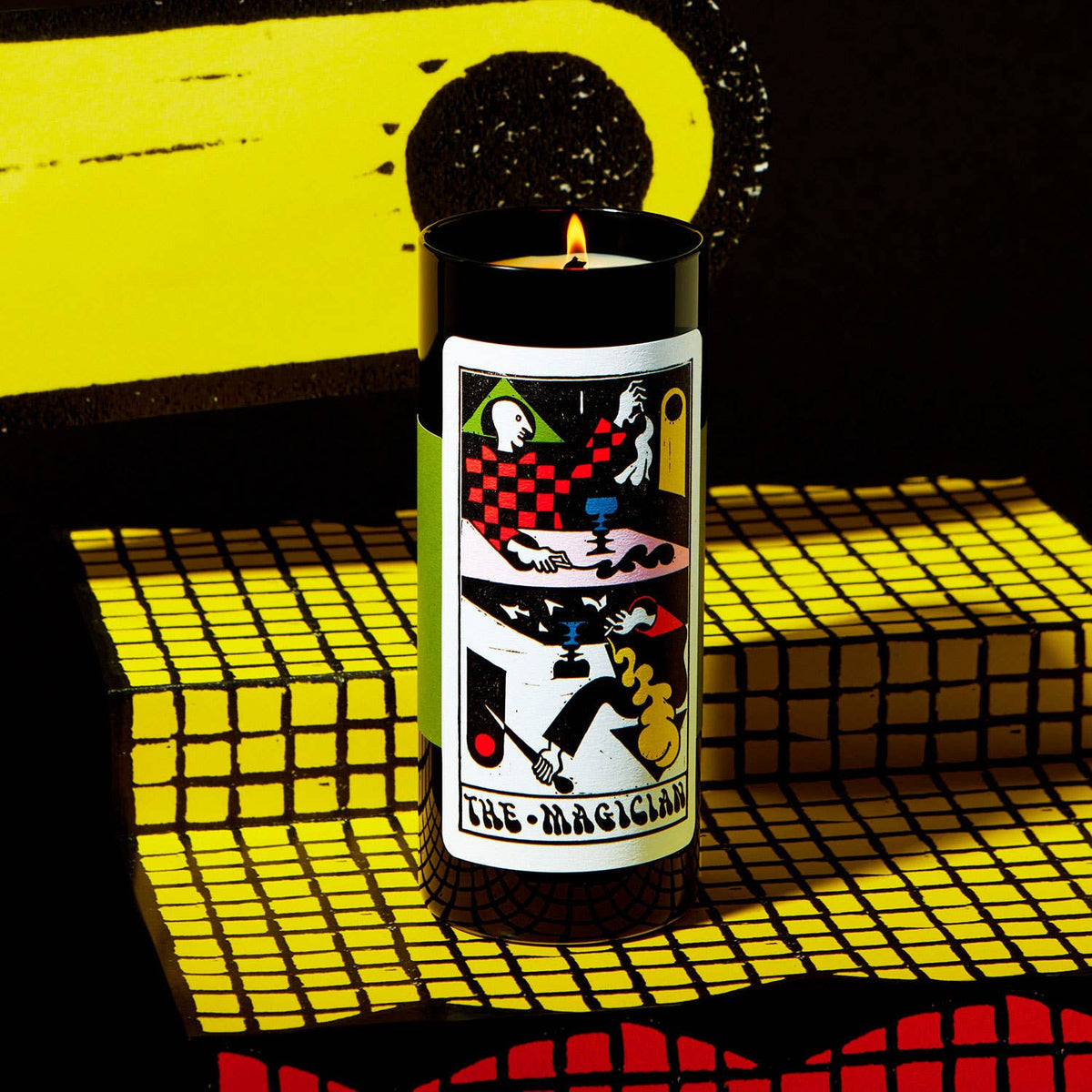 Candle with a colorful label on a yellow and black checkered surface