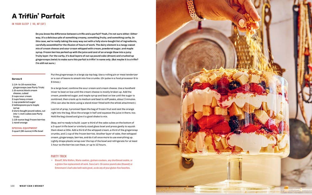 Page from a cookbook showing a layered dessert with berries and cream, held by a hand.