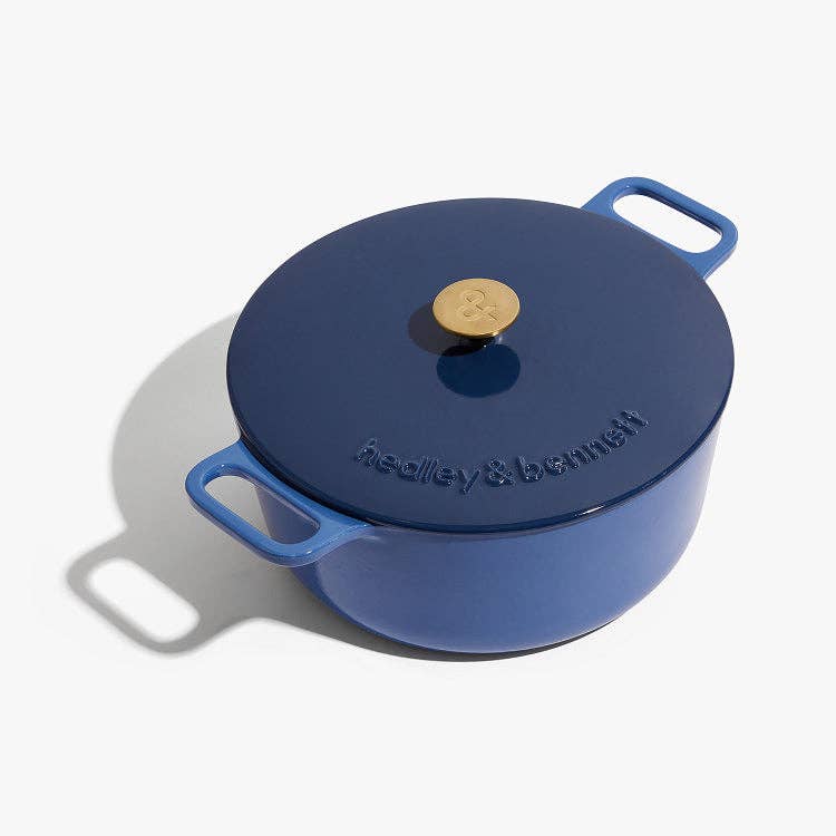 Blue cast iron cookware with a lid on a white background