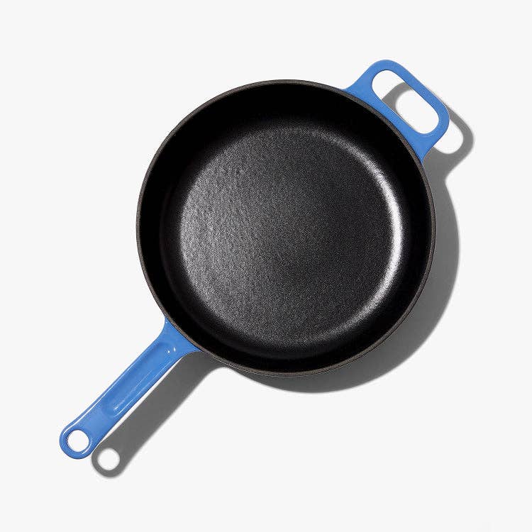 Black frying pan with blue handles on a white background