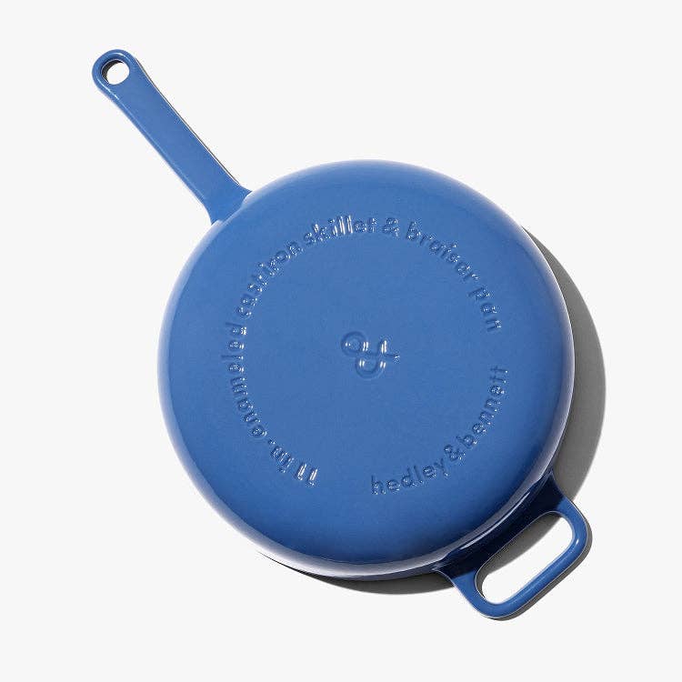 Blue cast iron skillet with lid on a white background