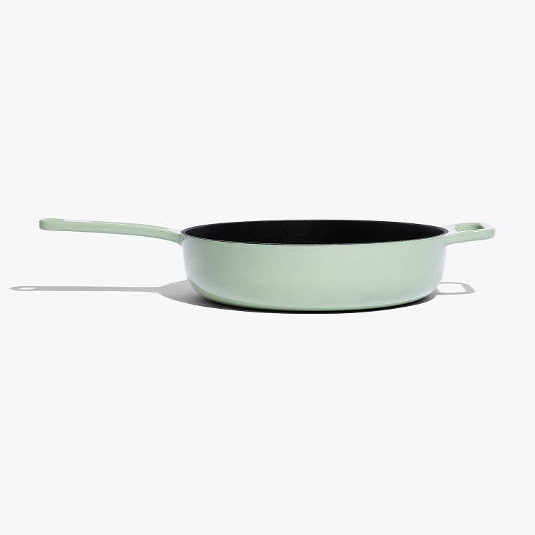 Light green frying pan with black interior on a white background