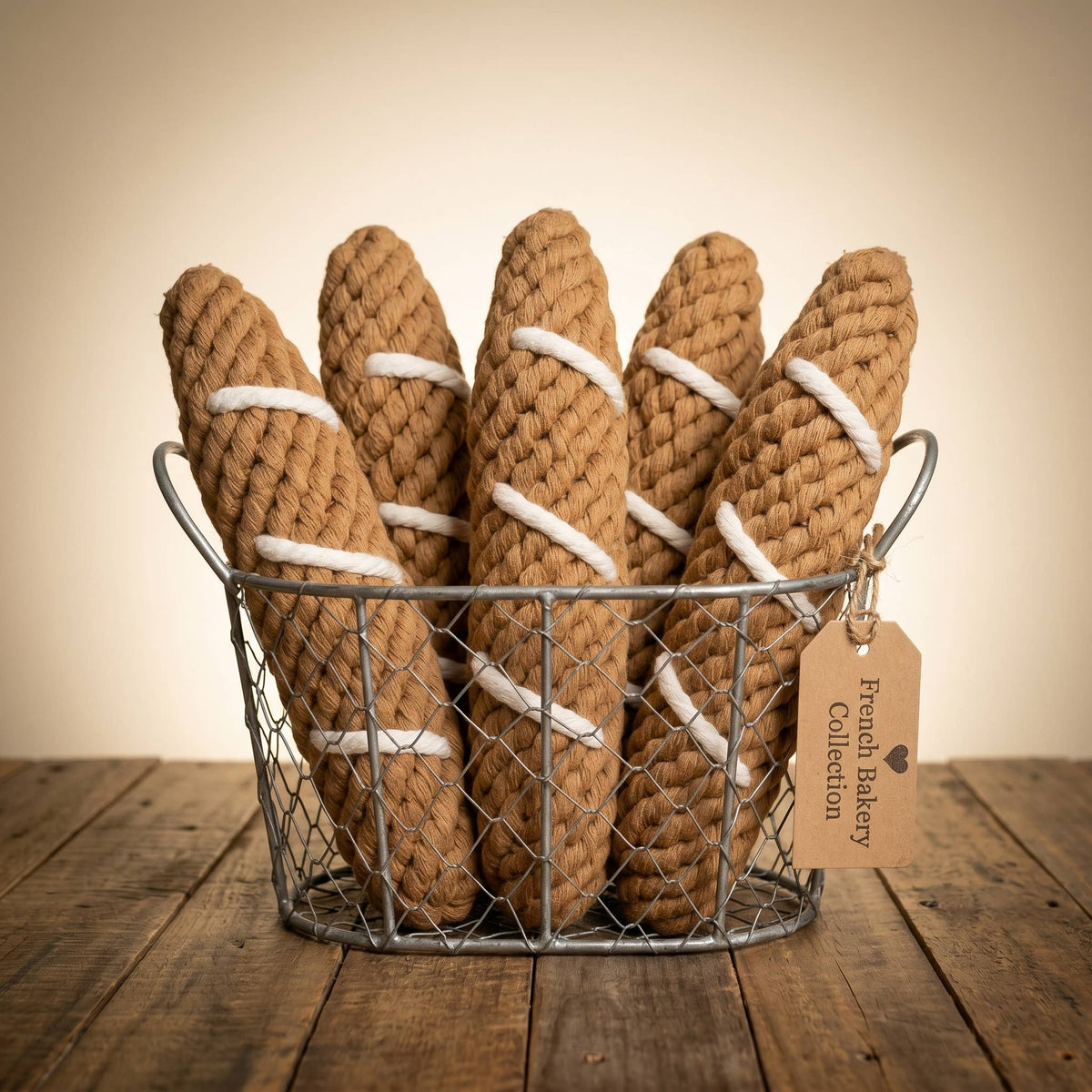 Rope chew toys for dogs that look like baguettes sitting in a wire basket 