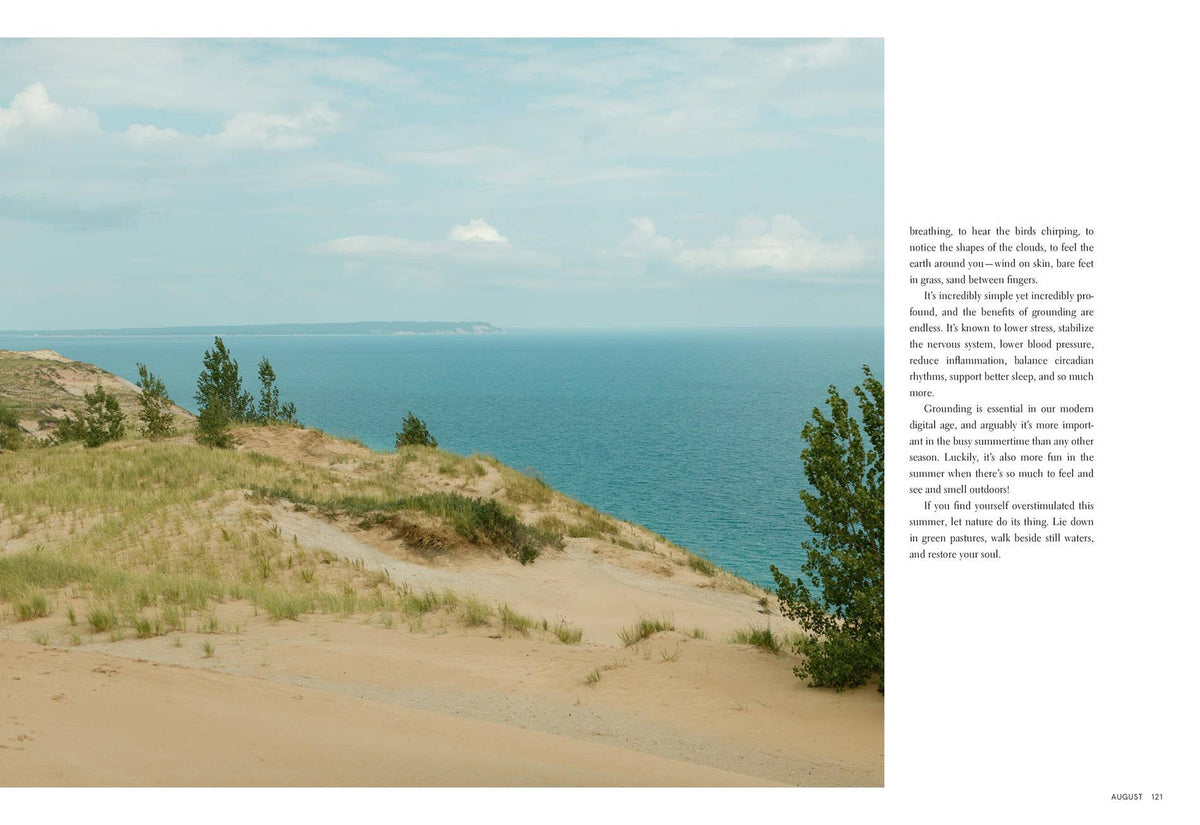 Scenic view of a beach with sand dunes and ocean under a blue sky.