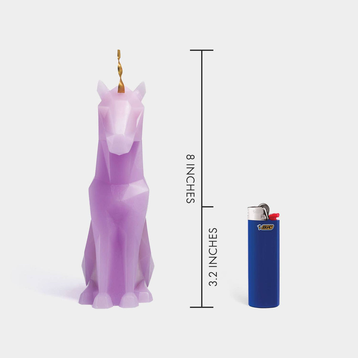 Purple unicorn candle with dimensions shown next to a lighter on a white background