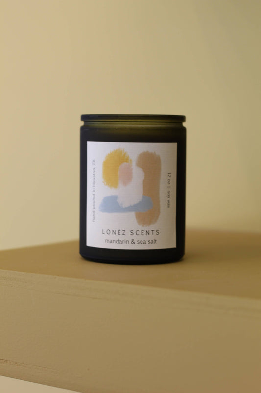 Candle with a label on a beige surface and background