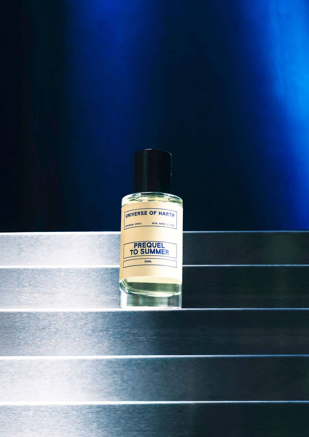 Bottle of 'Prequel to Summer' by Universe of Many on a reflective surface with a dark blue background