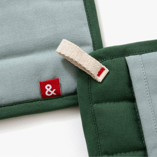 Two green and gray fabric pouches with a red and white logo tag on a white background