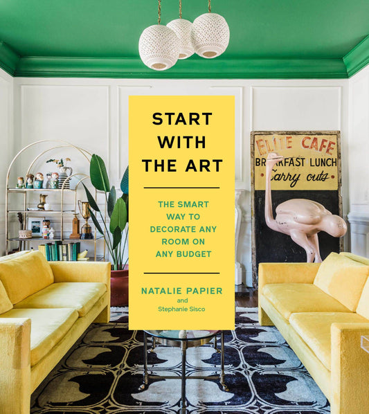 Book titled 'Start with the Art' in a stylish living room with yellow couches and green walls.