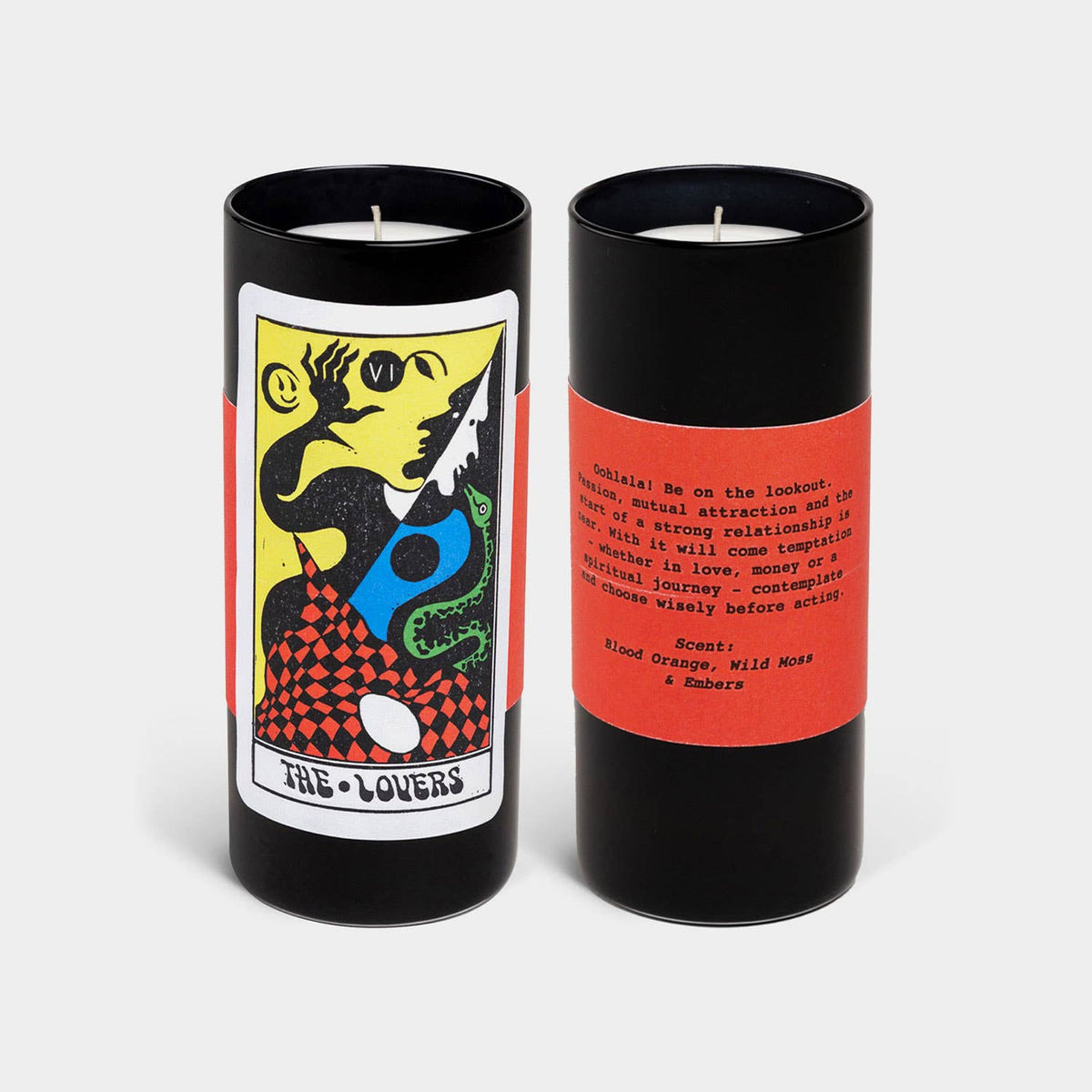 Two candles in black tins with colorful labels on a white background