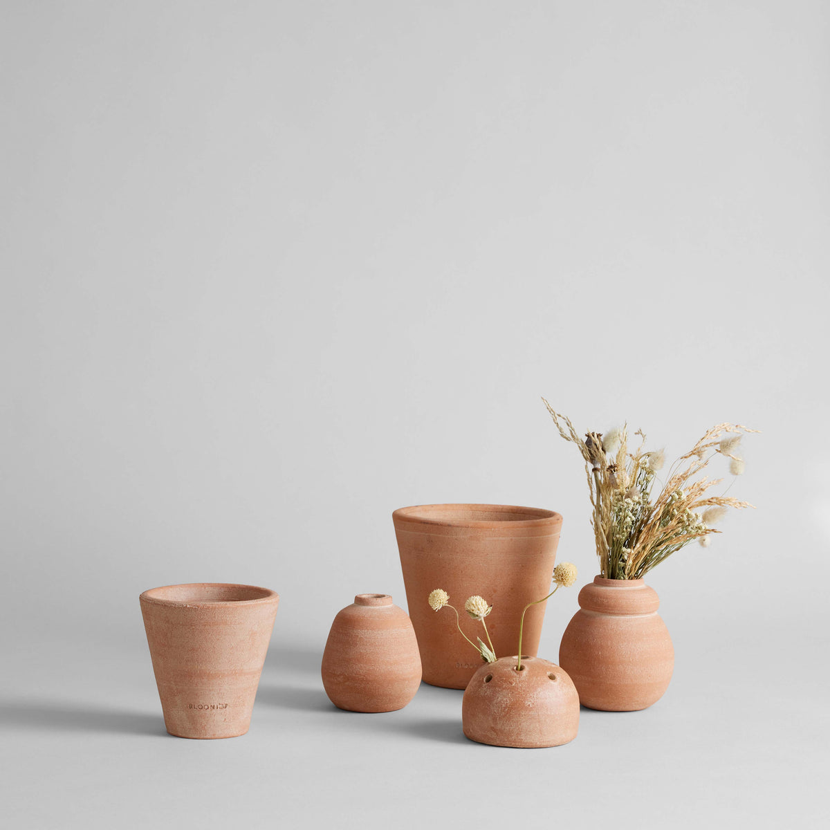 Set of terracotta vases on a light gray background