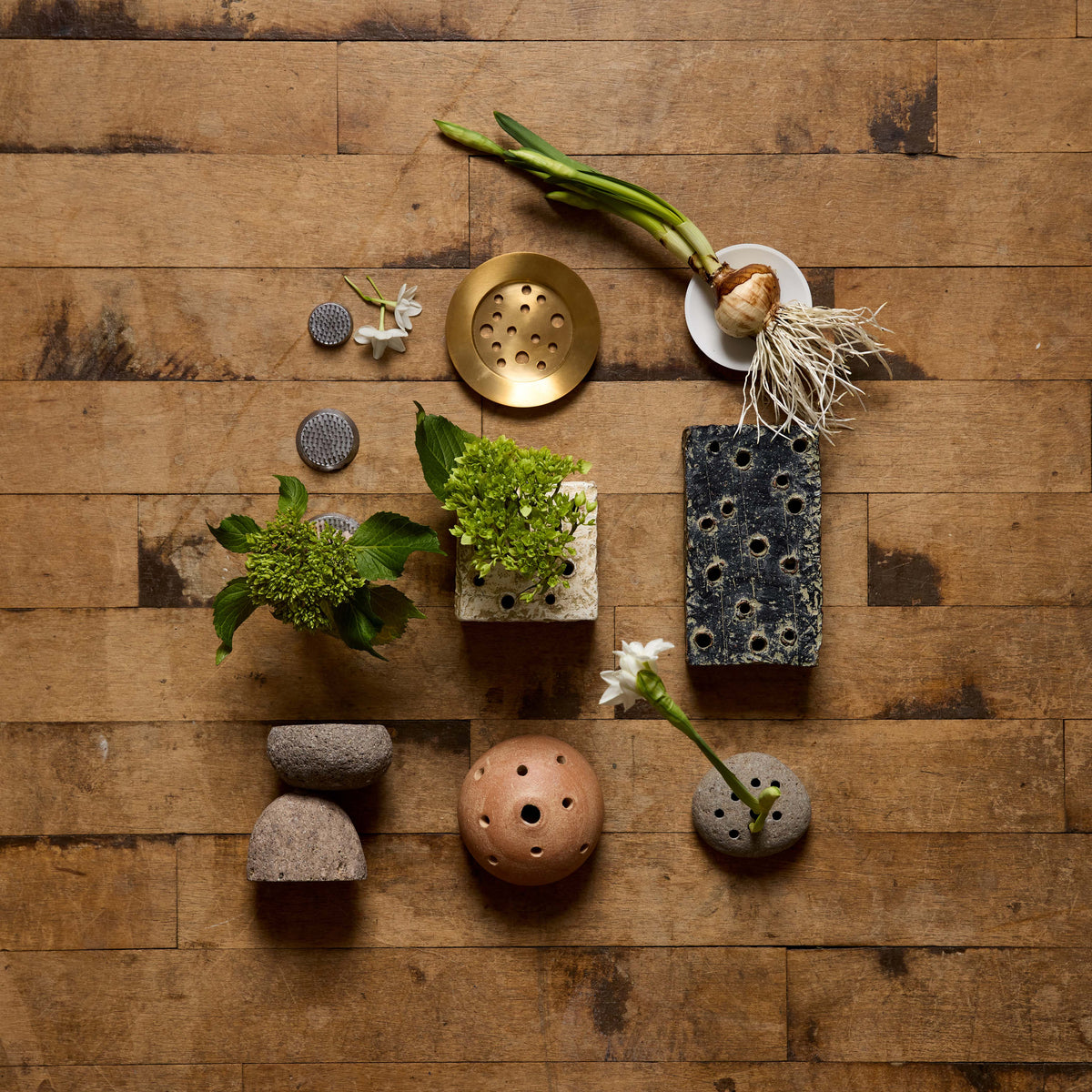 Decorative items including plants, stones, and ceramic pieces on a wooden surface