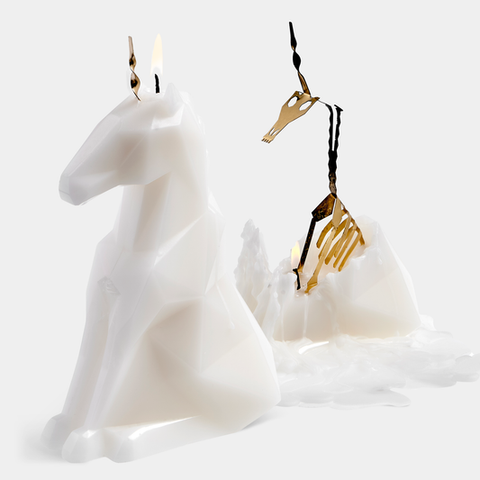 White horse-shaped candle with gold accents on a white background